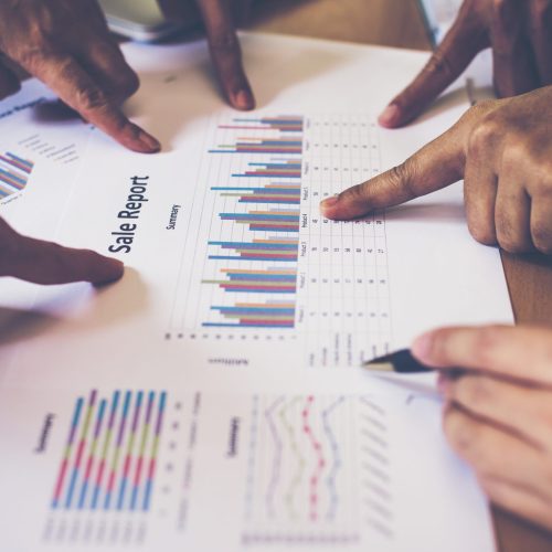 Group of business partners discussing ideas analysis and planning work in office.